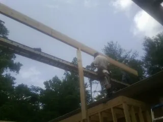 Carpenter setting a ridge beam over a new addition frame — Ice Dam Removal by Roofing Brothers in Dickerson Run
