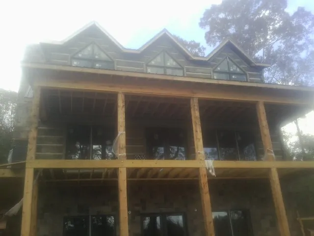 Dormers and porch framing on a large log home under construction — Roof Coating work by our crew in Dickerson Run